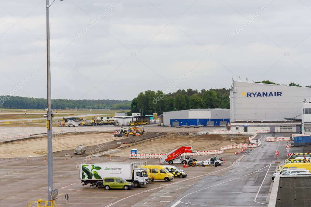 Nuremberg, Germany - 25th May 2025: Airport scene with construction, service vehicles, and a Ryanair building under a cloudy sky.