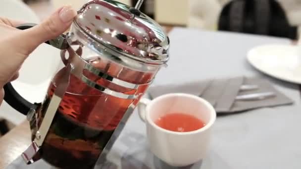 Weibliche Hand Gießt Tee Aus Einer Teekanne Eine Tasse Nahaufnahme — Stockvideo