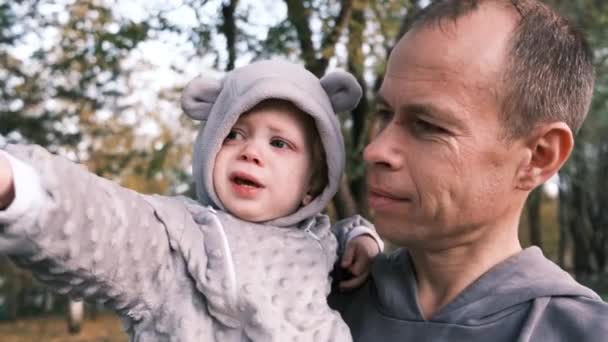 一个父亲把他的儿子抱在树间的画像 高质量的4K镜头 — 图库视频影像