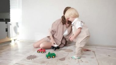 Genç anne, küçük oğluyla yatak odasında oyuncak oynuyor. Yüksek kalite 4k görüntü