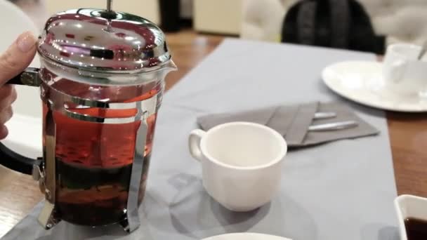 Weibliche Hand Gießt Tee Aus Einer Teekanne Eine Tasse Hochwertiges — Stockvideo