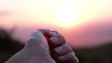 Zarif kadın eli gün batımında yumruğunu açar. Yüksek kalite 4k görüntü