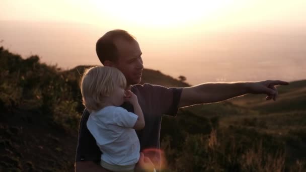 Father Holds His Son His Arms Points His Finger Distance — Vídeo de Stock