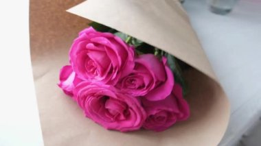 Close-up of a bouquet of pink roses wrapped in paper. High quality 4k footage
