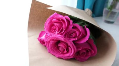 Close-up of a bouquet of pink roses wrapped in paper. High quality 4k footage