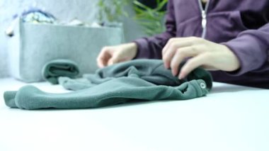 Womens hands fold clothes in a laundry room. High quality 4k footage