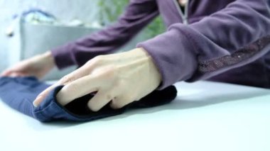 Womens hands fold clothes in a laundry room. High quality 4k footage