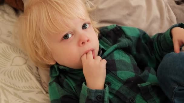 Der Junge Liegt Mit Den Fingern Mund Auf Dem Kissen — Stockvideo