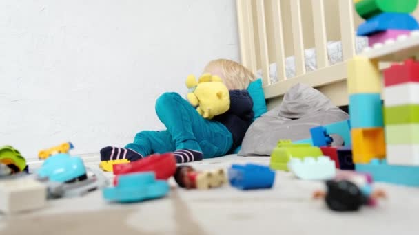 Αγόρι Βρίσκεται Στο Παιδικό Δωμάτιο Ανάμεσα Στα Παιχνίδια Υψηλής Ποιότητας — Αρχείο Βίντεο