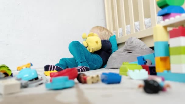Αγόρι Βρίσκεται Στο Παιδικό Δωμάτιο Ανάμεσα Στα Παιχνίδια Υψηλής Ποιότητας — Αρχείο Βίντεο