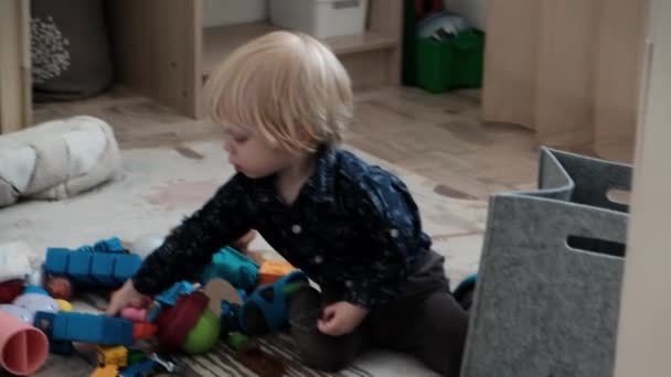 床の子供部屋では かわいい男の子がおもちゃで遊んでいます 高品質4K映像 — ストック動画