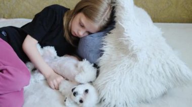 Yatağında beyaz bir köpek olan kız. Yakın plan. Yüksek kalite 4k görüntü