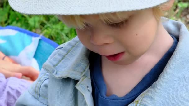 Een Drie Jaar Oude Jongen Met Een Hoed Eet Een — Stockvideo
