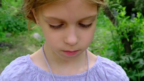 Uma Menina Triste Olha Para Uma Flor Arrancada Por Ela — Vídeo de Stock