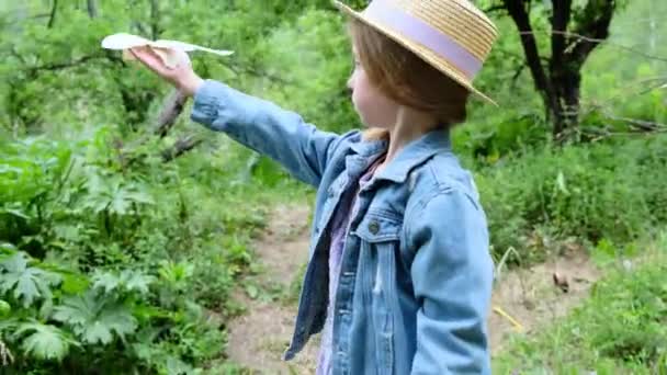 一个戴帽子的女孩把纸鸟抛向自然界中的空气 高质量的4K镜头 — 图库视频影像