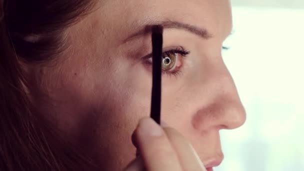 一位漂亮的中年妇女用刷子在眉毛上涂了点颜色 高质量的4K镜头 — 图库视频影像