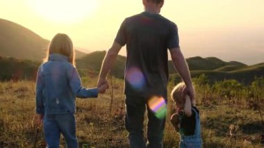 Mutlu aile kavramı. Güneşe doğru. Babam ve çocuklar gün batımında. Yüksek kalite 4k görüntü