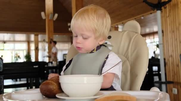 Copil Stă Scaun Înalt Într Restaurant Mănâncă Pâine Înregistrare Înaltă — Videoclip de stoc