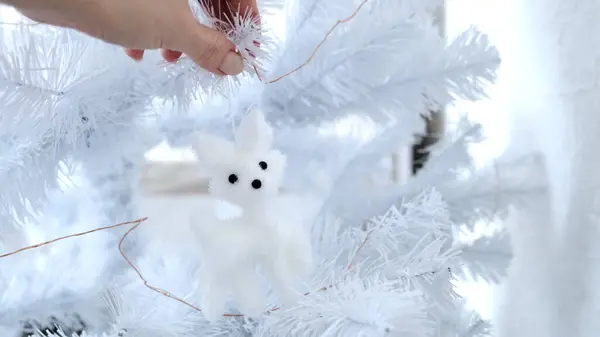 Bir kadının eli Noel ağacına oyuncak asar. Beyaz arka plan. Yüksek kalite 4k görüntü