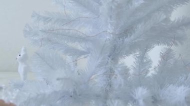 Kız bir Noel ağacına kar tanesi asıyor. Beyaz arka plan. Yüksek kalite 4k görüntü