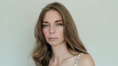 Gizemli genç kadın kameraya bakar ve gülümser. Yakın plan. Yüksek kalite 4k görüntü