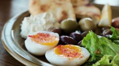 Haşlanmış yumurta, ot, salata ve bol zeytinli mükemmel bir kahvaltı. Yüksek kalite 4k görüntü