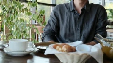 Restoranda oturan bir adam, gözlerinde bir fikirle pencereden dışarı bakar. Yüksek kalite 4k görüntü