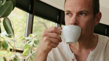 Kahvesini içerken düşünceli bakışları olan orta yaşlı bir adamın yakın çekimi. Yüksek kalite 4k görüntü