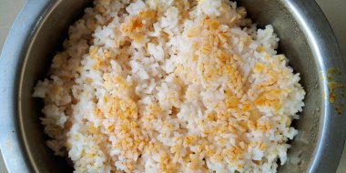 Bir metal kase pişmiş beyaz pirinçle doldurulur, üzerine mercimek ya da baharat parçaları serpiştirilir..