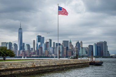 Amerikan bayrağıyla Özgürlük Adası 'ndan New York Manhattan silueti