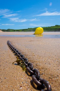 Marine Simplicity Chain Leading to a Yellow Buoy on the Shore clipart