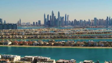 BAE 'deki Dubai' nin Palm Jumeirah 'ının çarpıcı hava manzarası. 4K Drone, güneşli bir günde mavi denizleri ve The Palm 'ı gösteriyor. Metro tramvayı mavi körfez denizi ile palmiyenin ortasından görülebilir..