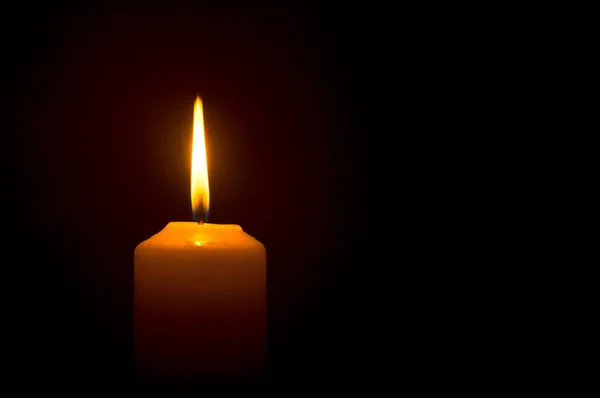 크리스마스 장례식 추도식을 테이블 위검은 어두운 배경에 노란색 촛불이 타오르고 — 스톡 사진