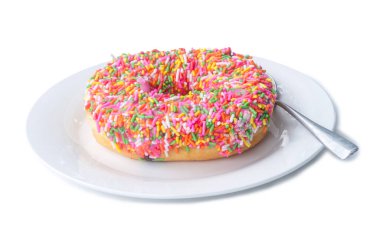 Küçük kaşıkla beyaz tabakta tek renkli çikolata kaplı donut kesme yolu ile beyaz arka planda izole edilir. Çok güzel ve rengarenk şekerli donut. 