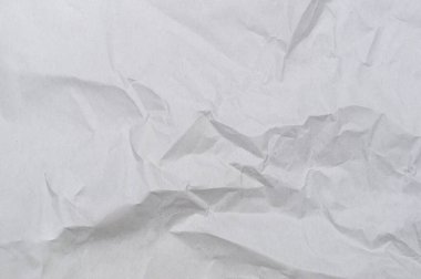 Wrinkled or crumpled white stencil paper or tissue after use in toilet or restroom with large copy space is used for background texture in decorative art work.
