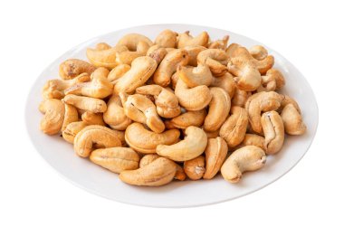 Roasted brown cashew nuts in stack on white plate is isolated on white background with clipping path.