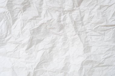 Wrinkled or crumpled white stencil paper or tissue after use in toilet or restroom with large copy space is used for background texture in decorative art work.