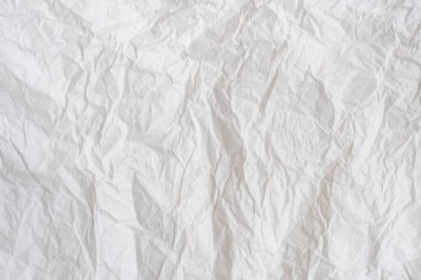 Wrinkled or crumpled white stencil paper or tissue after use in toilet or restroom with large copy space is used for background texture in decorative art work.