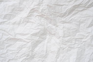 Wrinkled or crumpled white stencil paper or tissue after use in toilet or restroom with large copy space is used for background texture in decorative art work.