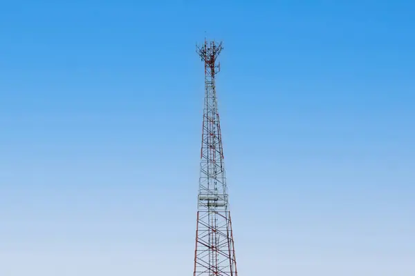 Internet signal tower or mobile phone signal tower is isolated on blue sky background texture. Global communication and internet network connection concept