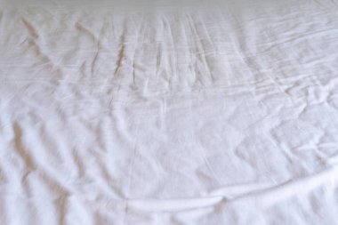 Crumpled or wrinkled white bedding sheet background texture was taken with soft natural light used for clothing background texture. clipart