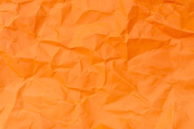 Üst görünüm ve buruşmuş veya buruşmuş turuncu kağıt dokusu dekoratif sanat eserlerinde buruşmuş kağıt arkaplan dokusu olarak kullanılır..