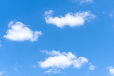 Güneşli bir günde sabah veya akşam tüylü beyaz bulutların tuhaf şekilli güzel mavi gökyüzünün alçak açısı dekoratif sanat eserlerinde doğal arkaplan dokusu olarak kullanılır..