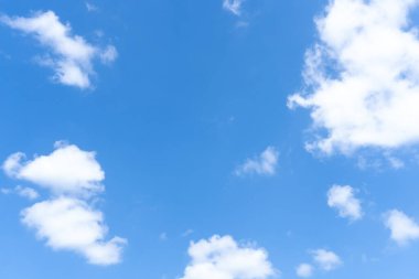 Güneşli bir günde sabah veya akşam tüylü beyaz bulutların tuhaf şekilli güzel mavi gökyüzünün alçak açısı dekoratif sanat eserlerinde doğal arkaplan dokusu olarak kullanılır..