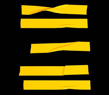 Kırışık ya da buruşuk sarı yapıştırıcı bant ya da şerit şeklinde kumaş bant kümesi siyah arkaplanda kırpma yolu ile izole edilmiştir..