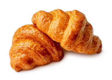 Yığındaki iki kahverengi veya altın kruvasan somununun yan görünümü kesme yolu ile beyaz arkaplanda izole edilmiştir.