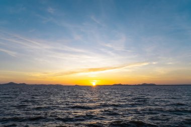 Güzel bir sabah ya da akşam mavi ve turuncu gökyüzü bulutlu günbatımları ya da günbatımları doğal arkaplan dokusu olarak kullanılan denizde çekilirken