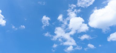 Güneşli bir günde sabah veya akşam tüylü beyaz bulutların tuhaf şekilli güzel mavi gökyüzünün alçak açısı dekoratif sanat eserlerinde doğal arkaplan dokusu olarak kullanılır..