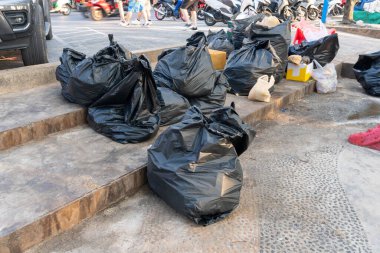 Şehir merkezindeki patikada çöp poşetlerinin içinde büyük bir çöp ya da atık grubu bulunuyor..
