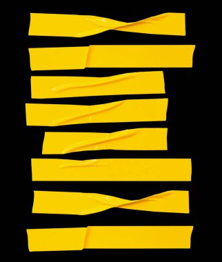 Kırışık veya buruşuk sarı yapıştırıcı bant veya çizgili kumaş bant kümesi ufuk şeklinde siyah arkaplanda kırpma yolu ile izole edilir..